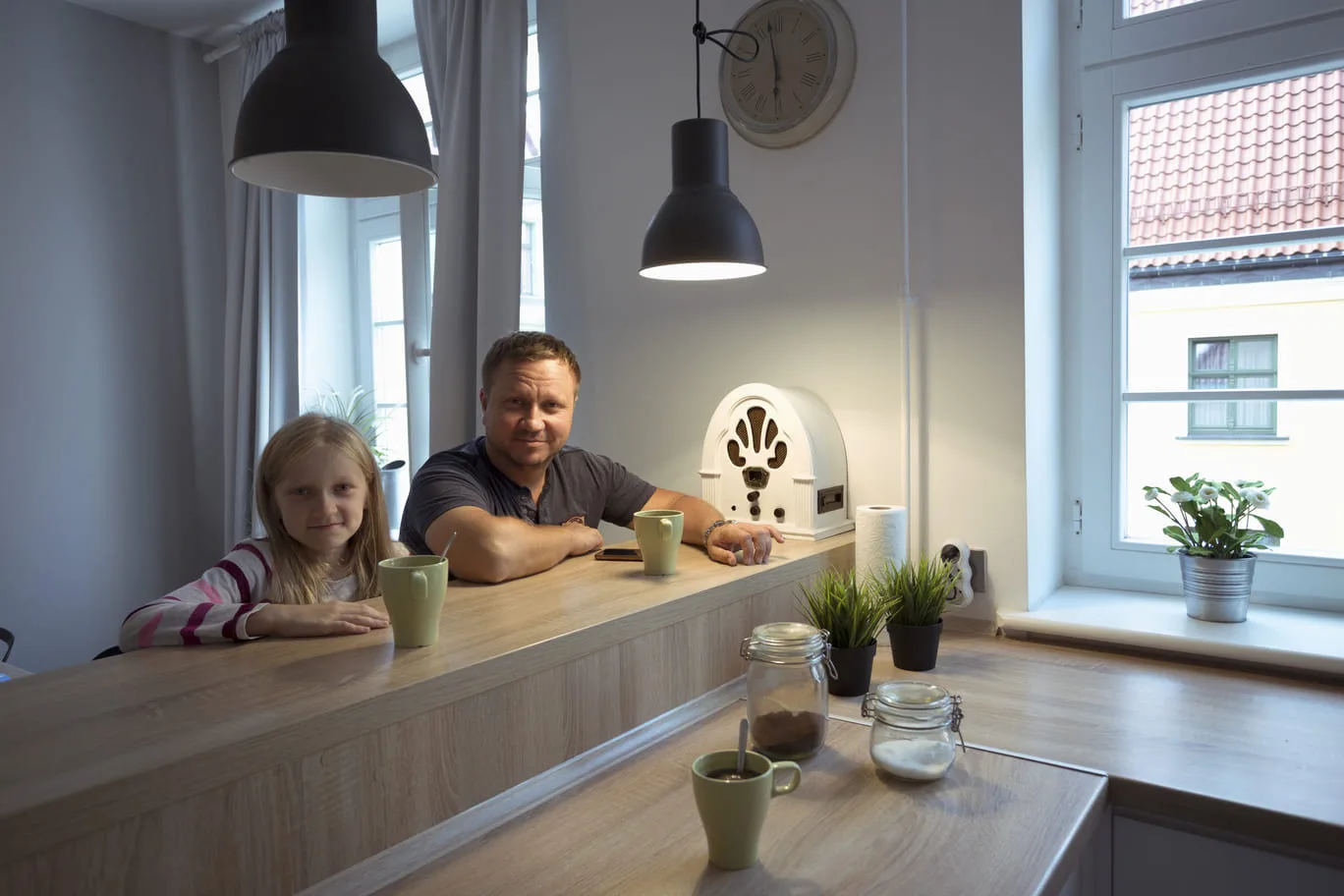 Onnellinen perhe keittiössä miettimässä mikä sähkösopimus kannattaa nyt kerrostaloon