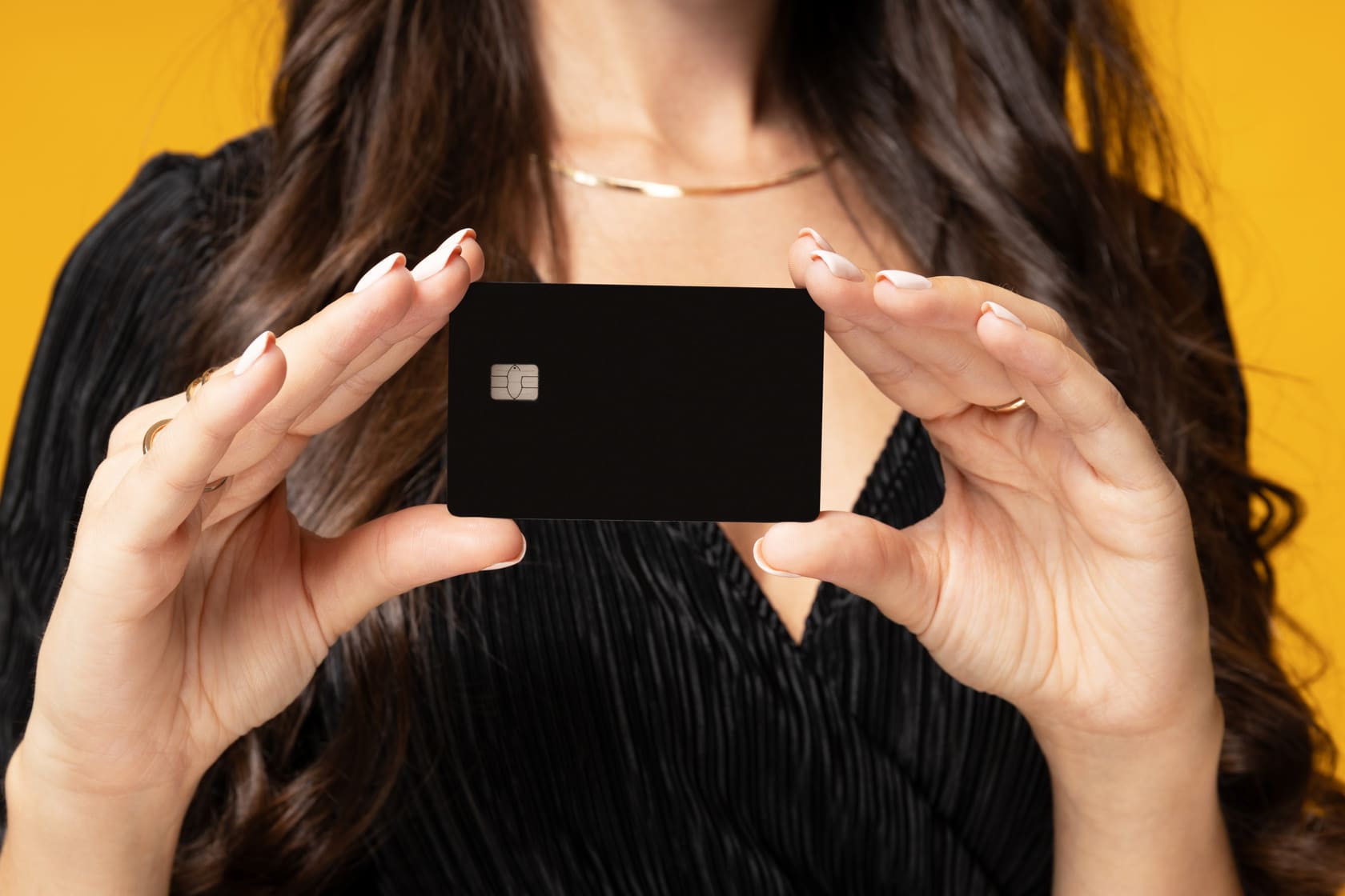 Nainen esittelee luottokorttia keltaisella taustalla - Instabank kokemuksia