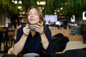 Nainen nauttii kahvia rauhassa kun on tehnyt yhdistelylainan ja talousasiat ovat järjestyksessä