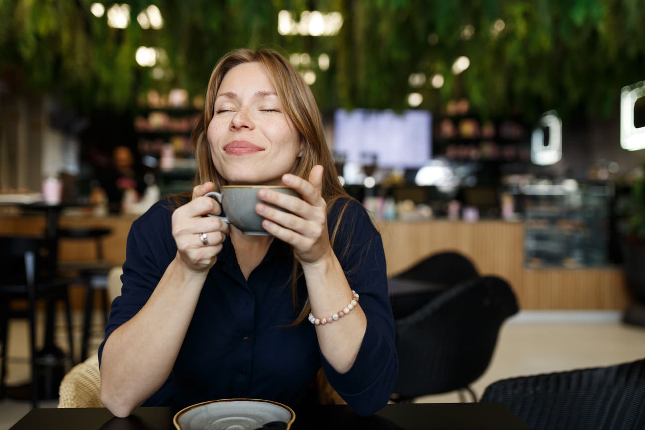 Nainen nauttii kahvia rauhassa kun talousasiat ovat järjestyksessä