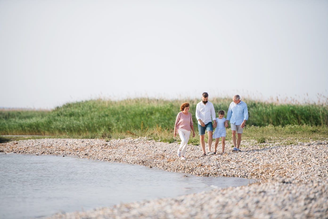 Perhe kävelee rannalla lomamatkalla – Northmill tuo turvaa matkustamiseen