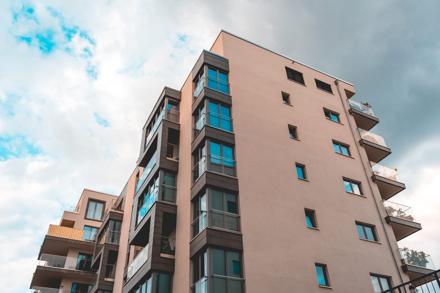 Oranssi kerrostalo lasitetuilla parvekkeilla - esimerkki kohteesta johon sähkösopimus haetaan