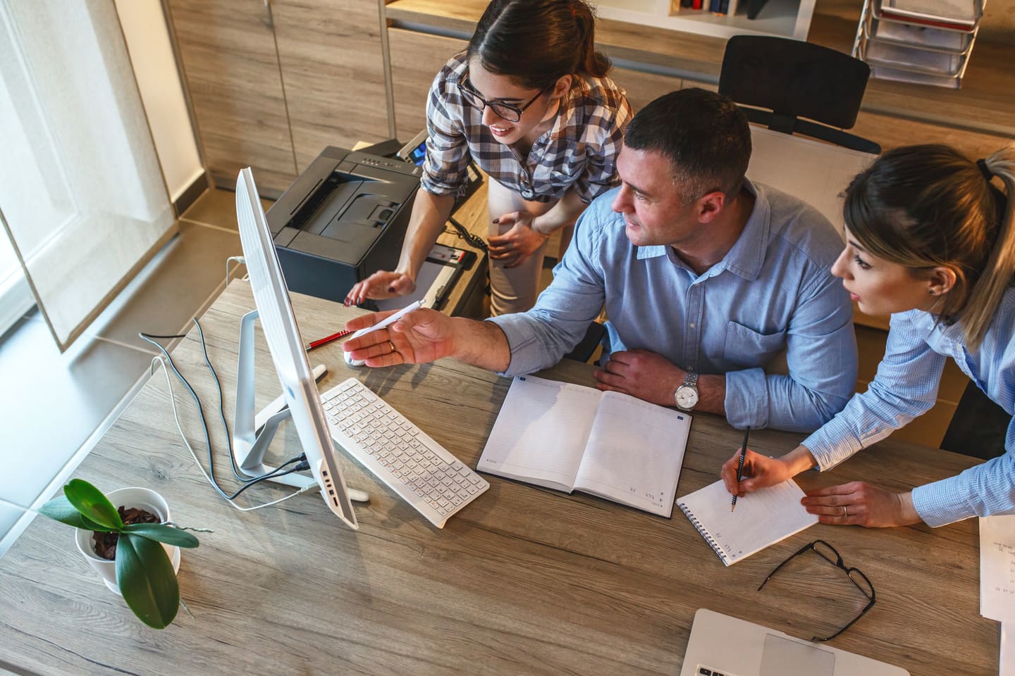Toimistotyöntekijät tutkivat yhdessä kuvaruutua kun aiheena on maksuvaran laskeminen ja luottotiedot 2026