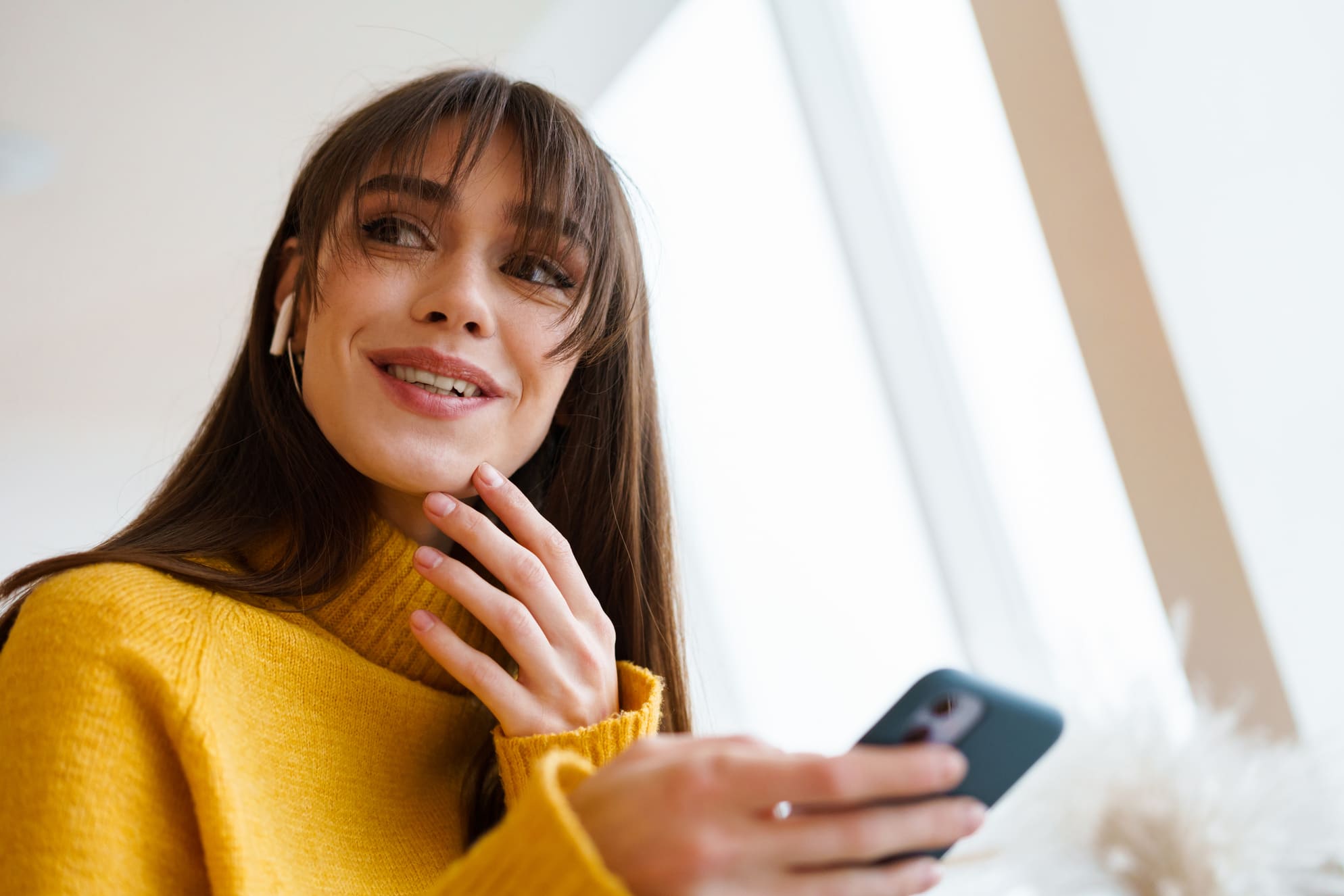 Iloinen opiskelija selaa puhelinta ja pohtii kuka voi saada lainaa eri elämäntilanteisiin vuonna 2026