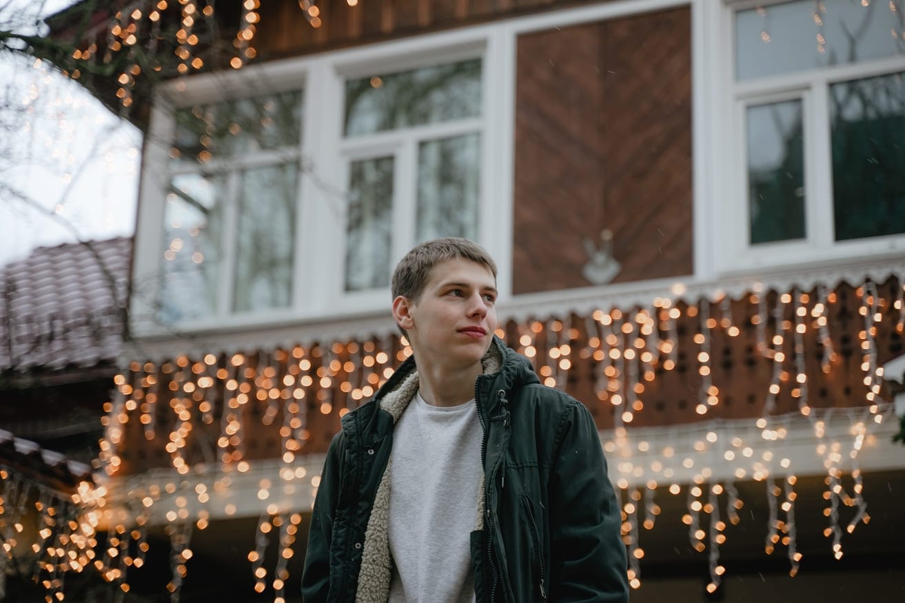 Nuori mies vertailee sähkösopimus tarjouksia talvipakkasilla ulkona