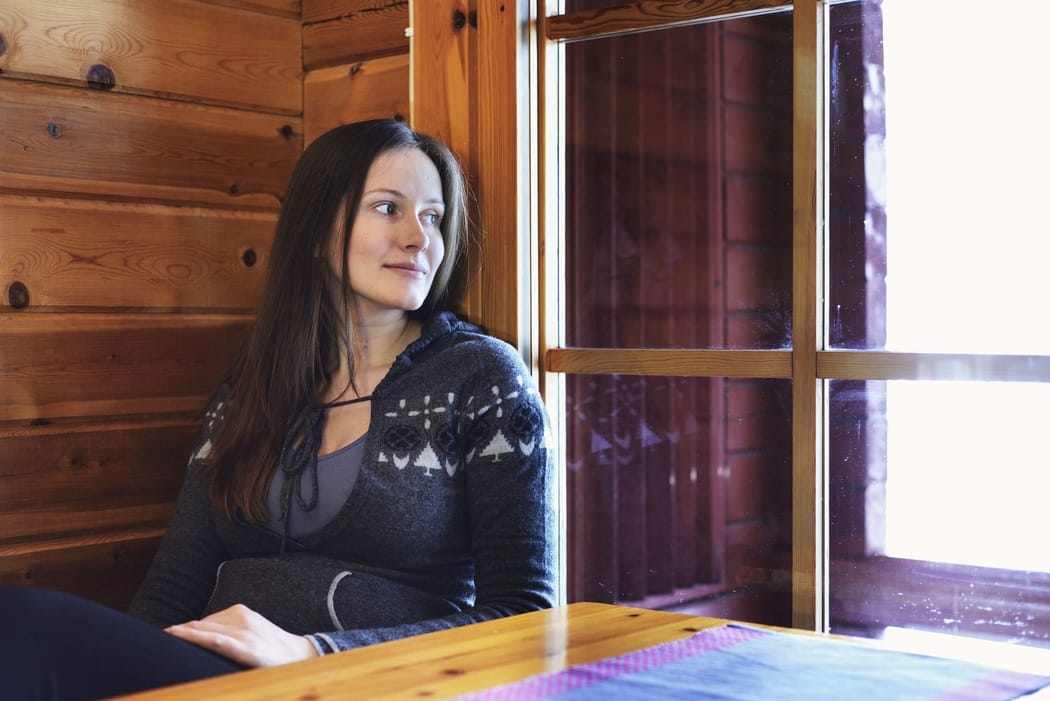 Sähkösopimus Keminmaa 2026 - Löydä edullisin sähkö 2 Nuori nainen katselee ikkunasta talvista maisemaa - Keminmaan sääolosuhteet vaativat hyvän sähkösopimuksen