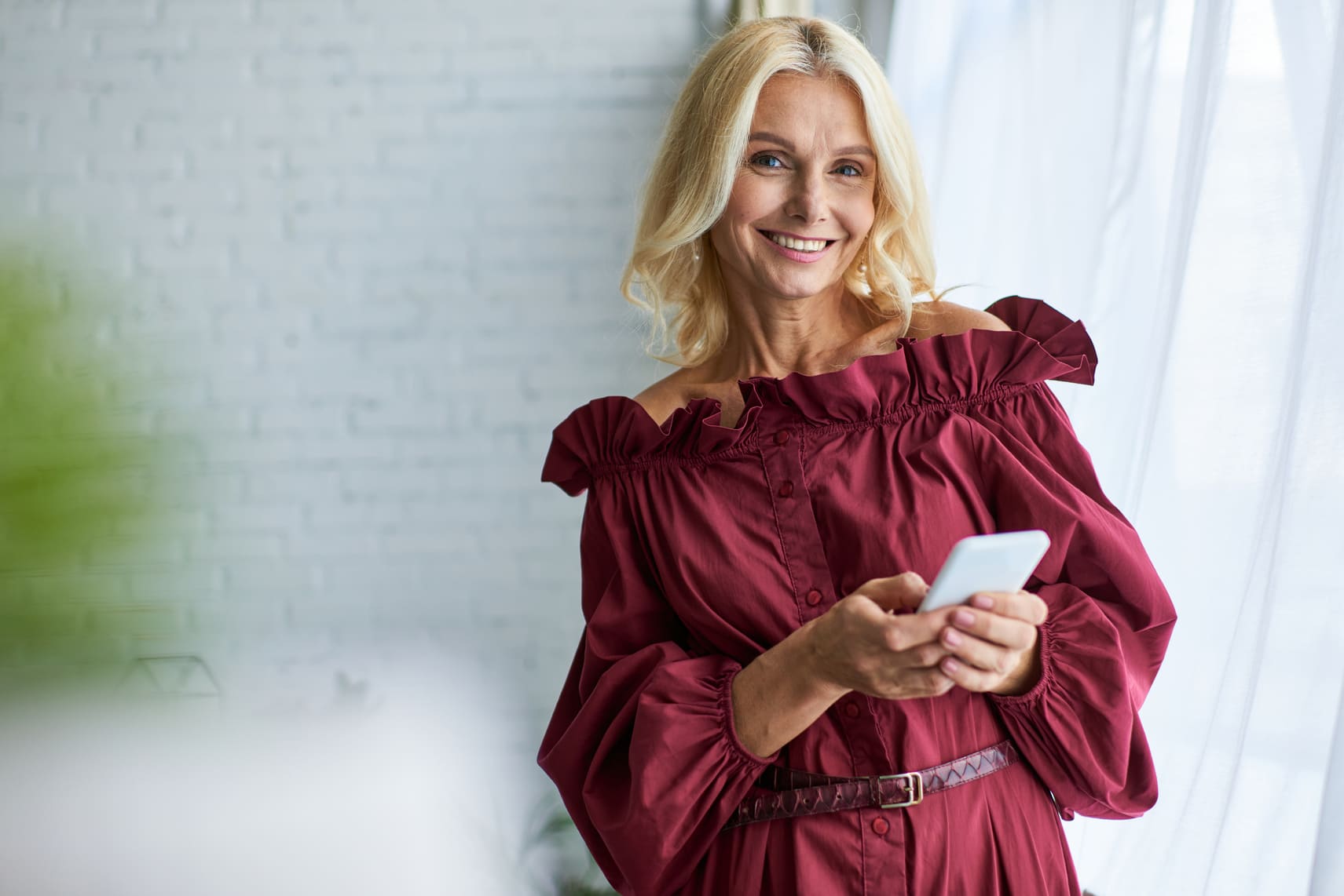 Nainen punaisessa mekossa hakee 7000 euroa lainaa puhelimella