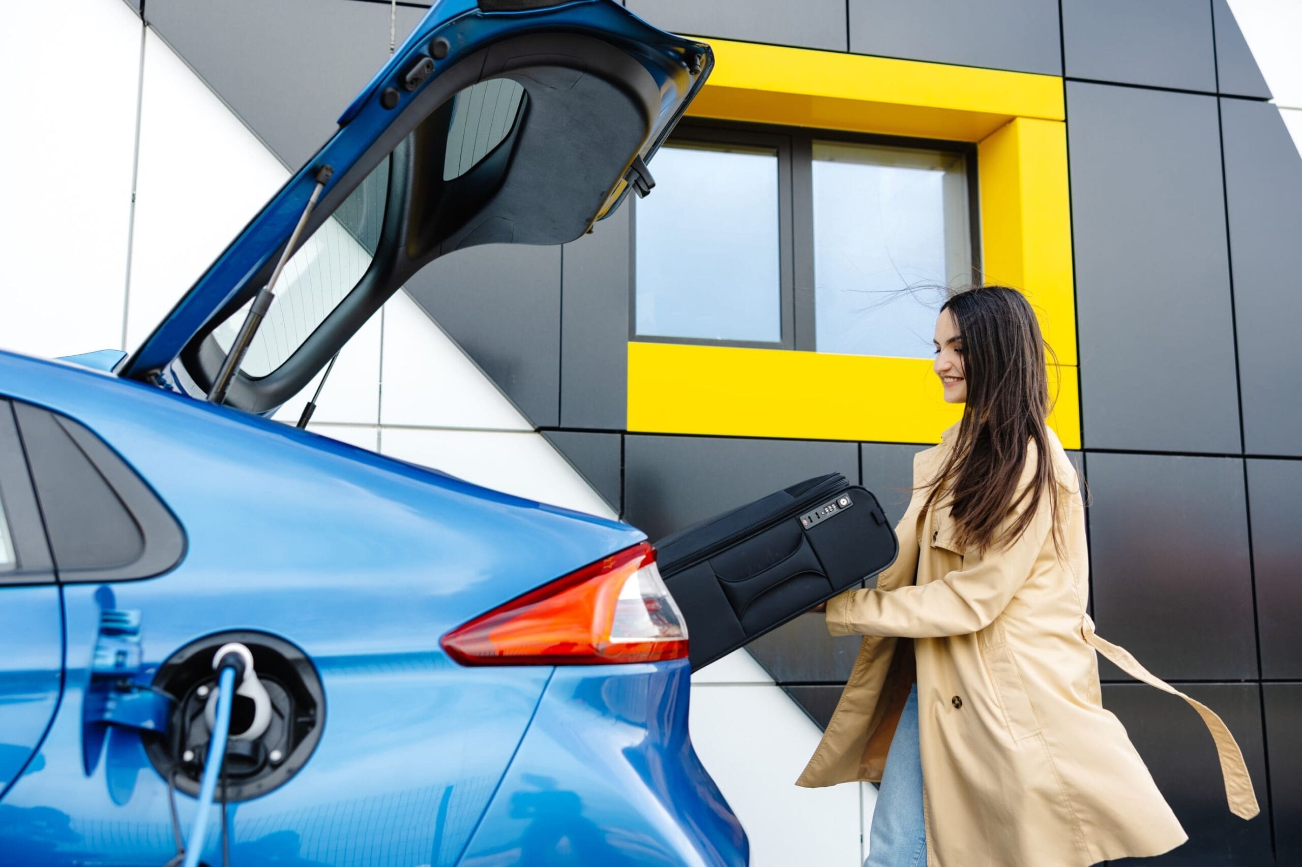 Nainen lataa sähköautoa vihreä laina turvin