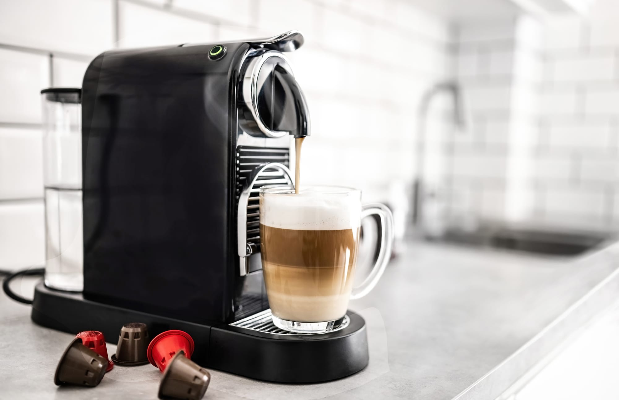 Kapselikeitin modernissa keittiössä valmistamassa kahvia