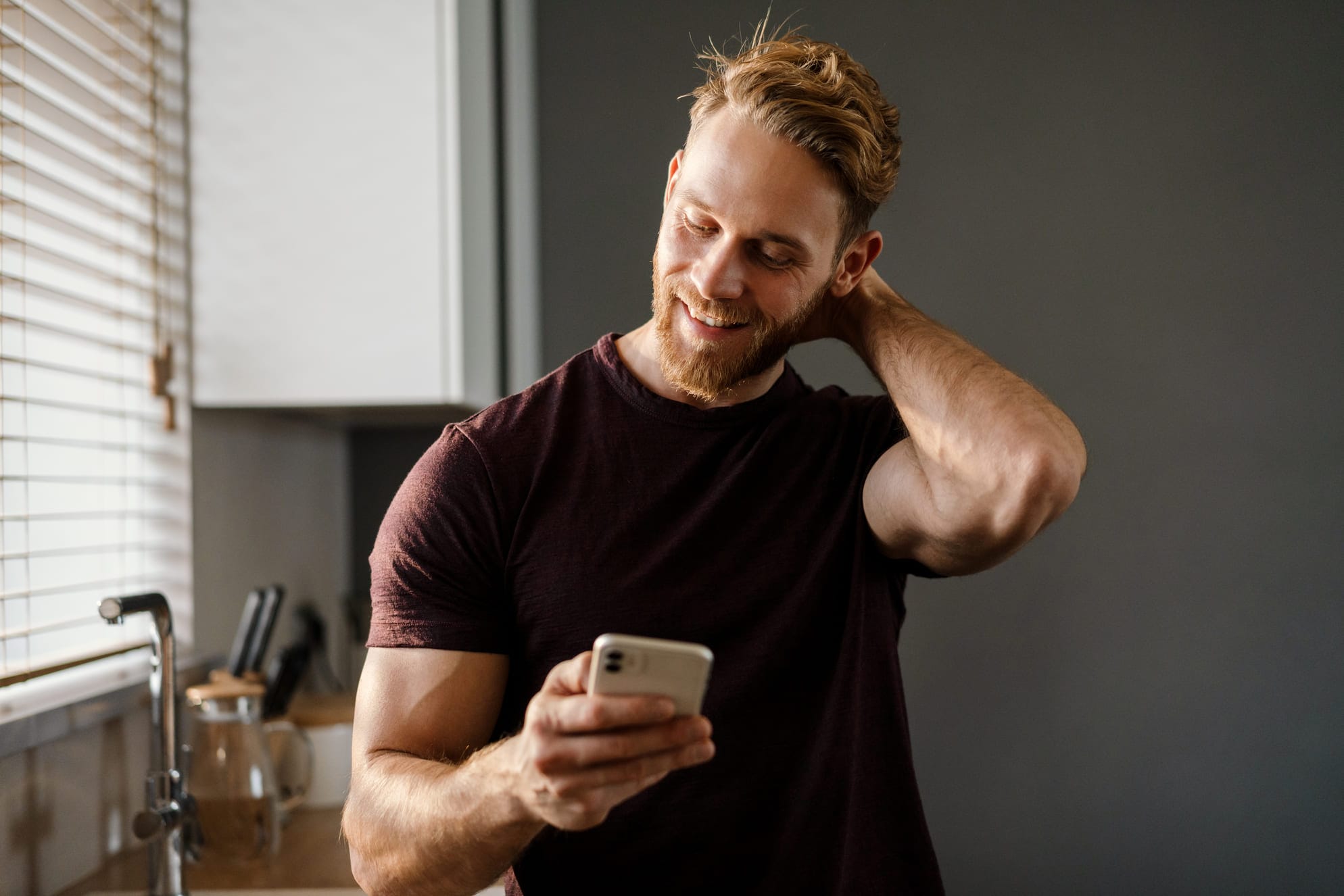 Mies katsoo puhelintaan lämpimässä mökissä Mäntyharjulla