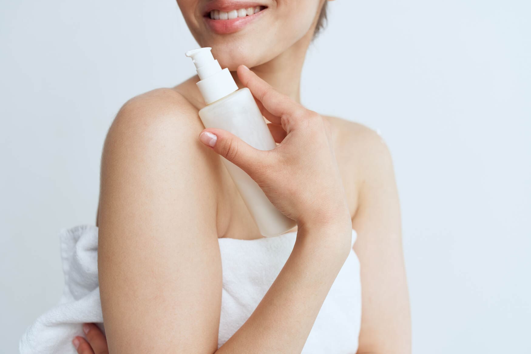 Nainen levittää ylellistä vartalovoidetta iholleen