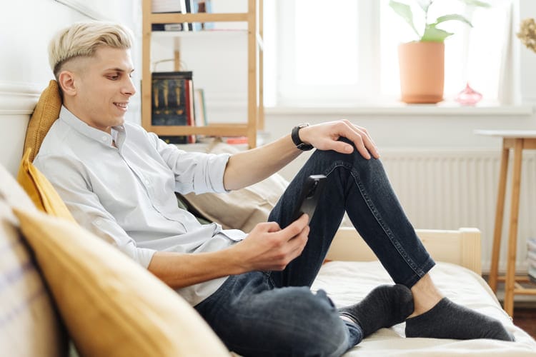 Nuori mies vertailee sähkösopimuksia Pietarsaareen kännykällään